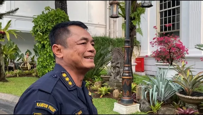 Prabowo Panggil Dirjen Bea Cukai Djaka Budhi Utama, Instruksikan Pengawasan Perbatasan dan Pesisir Diperketat Jakarta, 22 September 2026 – Presiden Prabowo Subianto memanggil Direktur Jenderal Bea dan Cukai Kementerian Keuangan Djaka Budhi Utama ke Kompleks Istana Kepresidenan, Jakarta, Selasa, 22 September 2026. Djaka tiba sekitar pukul 15.30 WIB dengan mengenakan seragam Bea Cukai. Saat tiba, ia belum menjelaskan secara rinci agenda pertemuan dengan Presiden dan hanya menyatakan belum mengetahui materi yang akan dibahas. Setelah pertemuan berlangsung, Djaka mengungkap salah satu arahan utama Prabowo adalah memperketat pengawasan di kawasan perbatasan dan wilayah pesisir Indonesia. Instruksi tersebut berkaitan dengan upaya mencegah masuknya barang ilegal melalui berbagai jalur. Menurut Djaka, Presiden memberikan perhatian terhadap pengamanan pintu-pintu masuk Indonesia yang rawan dimanfaatkan untuk penyelundupan. Bea Cukai diminta meningkatkan pengawasan tidak hanya di pelabuhan besar, tetapi juga pada jalur perairan dan kawasan perbatasan yang memiliki banyak akses tidak resmi. Pengawasan tersebut menjadi penting karena modus penyelundupan terus berkembang dan tidak selalu menggunakan jalur perdagangan formal. Pemerintah ingin memastikan barang yang masuk ke Indonesia memenuhi ketentuan kepabeanan serta aturan impor yang berlaku. Arahan tersebut juga berkaitan dengan perlindungan terhadap industri dan kegiatan ekonomi domestik. Pemanggilan Djaka berlangsung ketika Presiden menggelar rapat terbatas yang salah satu agendanya membahas industri tekstil dan produk tekstil atau TPT. Menteri Investasi dan Hilirisasi/Kepala BKPM Rosan Perkasa Roeslani sebelumnya menyebut sektor TPT termasuk dalam agenda pembahasan pemerintah. Kehadiran Dirjen Bea Cukai menjadi relevan karena pengawasan impor memiliki keterkaitan dengan perlindungan industri tekstil dalam negeri. Meski demikian, ketika baru tiba di Istana, Djaka belum memastikan apakah dirinya secara khusus dipanggil untuk membahas persoalan tersebut. Ia juga tidak memberikan keterangan mengenai kemungkinan adanya agenda lain yang dibahas langsung dengan Presiden. Pertemuan tersebut berlangsung hanya beberapa jam setelah Bea Cukai mengumumkan hasil penindakan terhadap dugaan impor ilegal beras, garam, dan pakaian bekas. Total nilai barang yang diamankan mencapai sekitar Rp27,34 miliar. Penindakan dilakukan di beberapa lokasi sepanjang Agustus hingga pertengahan September 2026. Bea Cukai menemukan indikasi pemberitahuan barang yang tidak benar atau misdeclaration dalam sejumlah pengiriman. Barang yang diamankan terdiri atas 30 kontainer berisi beras dan garam serta 1.435 bal pakaian yang diduga merupakan pakaian bekas. Salah satu penindakan dilakukan di Pelabuhan Tanjung Perak, Surabaya, pada 19 Agustus 2026. Sebanyak 15 kontainer diberitahukan berisi ammonium chloride asal India dengan berat total sekitar 412,5 ton. Setelah dilakukan pemeriksaan fisik dan laboratorium, petugas menemukan sekitar 202.450 kilogram beras dan 211.000 kilogram material yang diidentifikasi sebagai garam. Nilai barang dalam kasus tersebut diperkirakan mencapai Rp7,85 miliar. Bea Cukai menilai terdapat ketidaksesuaian material antara pemberitahuan dalam dokumen dan barang yang ditemukan. Kasus tersebut kemudian dikembangkan untuk menelusuri pengiriman lain yang menggunakan pola serupa. Pengembangan penindakan di Surabaya kemudian mengarah ke sebuah kawasan berikat di Bogor pada 7 September 2026. Bea Cukai mengamankan 15 kontainer yang diberitahukan berisi bahan kimia berupa garam untuk keperluan penyamakan kulit dengan berat sekitar 420 ton. Pemeriksaan fisik menemukan sekitar 194.900 kilogram beras dan 225.400 kilogram butiran putih yang diduga garam. Nilai keseluruhan barang tersebut diperkirakan mencapai Rp8 miliar. Bea Cukai menduga terdapat upaya menyamarkan muatan sebenarnya untuk memperoleh fasilitas tertentu dan menghindari ketentuan impor. Barang-barang tersebut telah diamankan untuk proses hukum lebih lanjut. Penindakan lainnya menyasar pakaian bekas atau balpres yang masuk melalui jalur laut. Di Perairan Gosong Bunga-Bunga, Serdang Bedagai, Sumatera Utara, petugas mengamankan 430 bal pakaian bekas serta empat koli suku cadang kendaraan bermotor dengan perkiraan nilai sekitar Rp3,4 miliar. Pemeriksaan lain dilakukan terhadap kontainer berisi balpres pakaian yang diduga bekas di Pelabuhan Tanjung Priok. Nilai barang dari penindakan tersebut diperkirakan mencapai sekitar Rp8,04 miliar. Pemerintah selama ini melarang impor pakaian bekas karena dinilai dapat mengganggu industri tekstil domestik serta melanggar ketentuan perdagangan. Penindakan tersebut menjadi salah satu konteks penting ketika pemerintah membahas kondisi industri TPT. Arahan Prabowo untuk memperketat perbatasan dan wilayah pesisir membuat Bea Cukai perlu memperkuat koordinasi dengan lembaga lain. Indonesia memiliki wilayah laut yang sangat luas dengan banyak jalur yang dapat dimanfaatkan untuk memasukkan barang tanpa melalui prosedur resmi. Pengawasan karena itu tidak dapat hanya mengandalkan pemeriksaan di pelabuhan utama. Patroli laut, pertukaran informasi, analisis risiko, serta koordinasi dengan aparat penegak hukum menjadi bagian penting dalam mencegah penyelundupan. Djaka menyatakan instruksi Presiden akan ditindaklanjuti oleh jajaran Bea Cukai. Selain pengamanan penerimaan negara, pengawasan impor juga mempunyai dampak terhadap industri nasional. Masuknya barang secara ilegal dapat menciptakan persaingan yang tidak seimbang karena produk tersebut berpotensi menghindari bea masuk, pajak, maupun persyaratan perdagangan lainnya. Kondisi tersebut menjadi perhatian khusus pada industri tekstil dan produk tekstil yang bersaing dengan produk impor. Pemerintah karena itu menghubungkan penguatan pengawasan kepabeanan dengan perlindungan kegiatan produksi dan tenaga kerja dalam negeri. Penindakan terhadap pakaian bekas impor menjadi salah satu contoh penerapan kebijakan tersebut. Pemerintah juga menekankan proses penegakan hukum harus dilakukan berdasarkan ketentuan yang berlaku. Pemanggilan Djaka ke Istana akhirnya menghasilkan arahan yang lebih jelas dibandingkan ketika ia pertama kali tiba. Presiden Prabowo meminta Bea Cukai meningkatkan pengamanan kawasan perbatasan dan pesisir untuk menekan penyelundupan serta masuknya barang ilegal. Instruksi tersebut muncul bersamaan dengan pengungkapan sejumlah kasus impor ilegal bernilai puluhan miliar rupiah dan pembahasan pemerintah mengenai industri tekstil nasional. Bea Cukai selanjutnya akan menindaklanjuti arahan Presiden melalui penguatan pengawasan dan koordinasi dengan instansi terkait. Pemerintah juga akan terus mengevaluasi jalur yang dinilai rawan digunakan untuk pelanggaran kepabeanan. Langkah tersebut diharapkan dapat menjaga penerimaan negara sekaligus melindungi kegiatan ekonomi dan industri domestik.